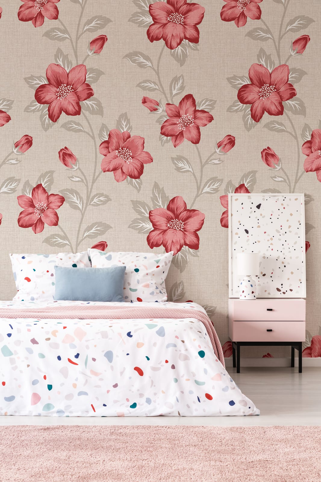 Warm guest room wall decor featuring floral wallpaper with bold red blossoms in soft neutral pattern, ideal for inviting space